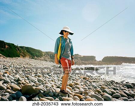 A man in summer beach wear standing on a rocky beach along the coast of Northern California's Pacific Coast Highway View Large Photo Image Stock Image - A man in summer beach wear standing on a rocky beach along the coast of Northern California's Pacific Coast Highway. Fotosearch