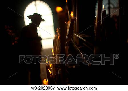 A man lights a candle in the Votive Room of the shrine of the Virgin of Rocio, in Almonte, Donana National Park, Huelva province, Andalusia, Spaine in Andalusia. View Large Photo Image Stock Photo - A man lights a candle in the Votive Room of the shrine of the Virgin of Rocio, in Almonte, Donana National Park, Huelva province, Andalusia, Spaine in Andalusia.. Fotosearch