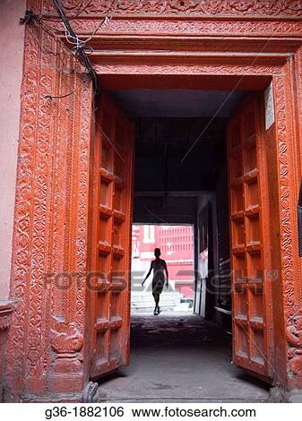 Stock Photograph - A man passes through a doorway in Haridwar in the state of Uttarakhand in northern India. Fotosearch
