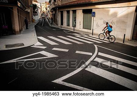 A man riding his bicycle down a street in Cubelles, Catalonia, Spain View Large Photo Image Stock Image - A man riding his bicycle down a street in Cubelles, Catalonia, Spain. Fotosearch