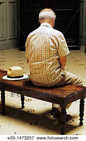 A man sits on a bench in a museum with his hat by his side View Large Photo Image Stock Photo - A man sits on a bench in a museum with his hat by his side. Fotosearch