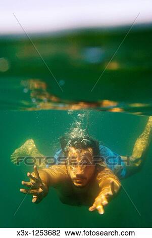 A man swimming underwater in the Mediterranean sea Italy View Large Photo Image Stock Image - A man swimming underwater in the Mediterranean sea Italy. Fotosearch