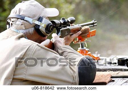 Stock Image - a man target shooting with a high powered rifle. Fotosearch