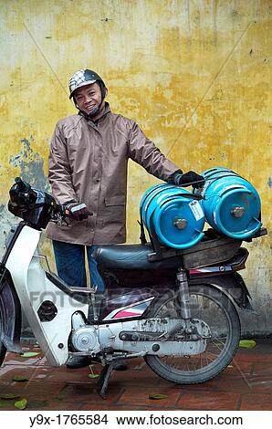A man transporting gas on his motorcycle in a temple in Vietnam View Large Photo Image Picture - A man transporting gas on his motorcycle in a temple in Vietnam. Fotosearch