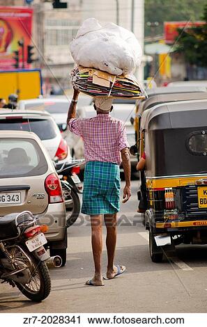 Stock Image - A man walks in busy traffic in Trivandrum, Kerala, South India.. Fotosearch