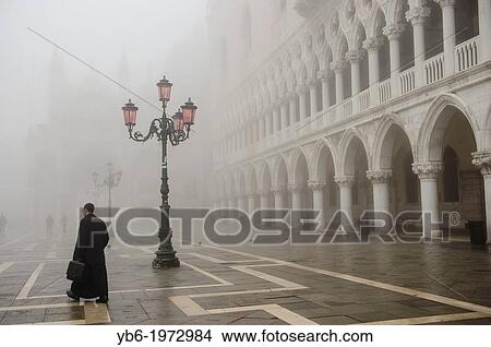 A man walks in St. Mark's Square In Venice covered in thick fog, Italy. View Large Photo Image Picture - A man walks in St. Mark's Square In Venice covered in thick fog, Italy.. Fotosearch