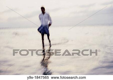 A man walks solemnly on a beach in India View Large Photo Image Stock Photography - A man walks solemnly on a beach in India. Fotosearch