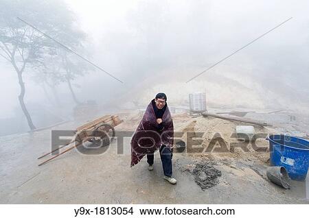 A man wrapped in a blanket and an old pull cart at the San Huang Zhai Monastery on Song Mountain, China View Large Photo Image Picture - A man wrapped in a blanket and an old pull cart at the San Huang Zhai Monastery on Song Mountain, China. Fotosearch