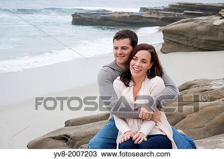 Stock Image - A married and smiling couple embracing at the beach.. Fotosearch