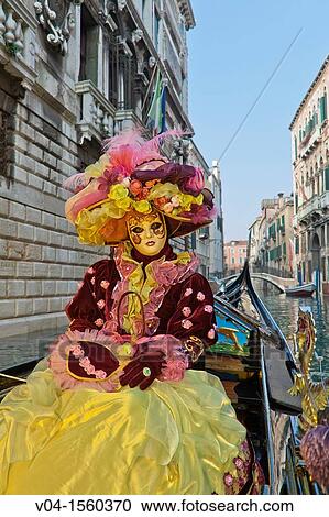 Stock Image - A masked woman in a gondola at the carnival in Venice, Italy, Europe. Fotosearch