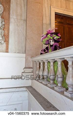 Stock Photography - A masked woman leaning over a balcony at the carnival in Venice, Italy, Europe. Fotosearch