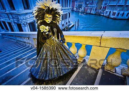 Stock Image - A masked woman on the Rialto Bridge at the carnival in Venice, Italy, Europe. Fotosearch