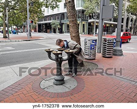 A mature woman drinks from a fountain on a downtown sidewalk in Portland, Oregon View Large Photo Image Stock Photo - A mature woman drinks from a fountain on a downtown sidewalk in Portland, Oregon. Fotosearch