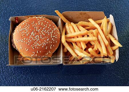 Stock Photo - A McDonalds quarter 1/4 pounder with cheese hamburger in it's box with french fries piled into the other side of the box. Fotosearch