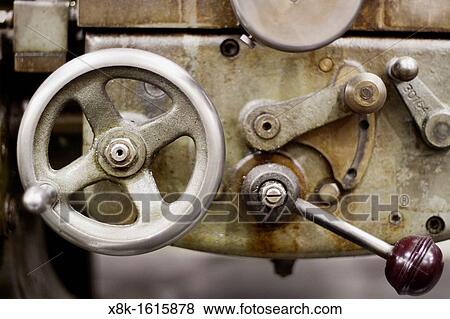 Stock Photo - A metal wheel and lever on a piece of metalworking machinery.. Fotosearch