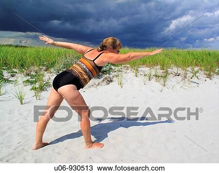 a middle age woman doing yoga at the beach View Large Photo Image Stock Image - a middle age woman doing yoga at the beach. Fotosearch