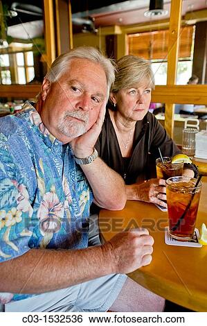 A middle aged couple appeared indifferent to each others? company over iced tea together in a Long Beach, CA, restaurant View Large Photo Image Stock Photograph - A middle aged couple appeared indifferent to each others? company over iced tea together in a Long Beach, CA, restaurant. Fotosearch