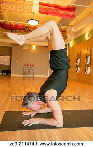 Stock Photo - A middle-aged man demonstrates an ashtanga yoga pose.. Fotosearch