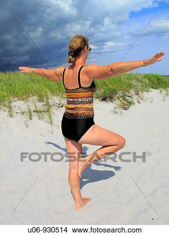 a middle aged woman doing yoga at the beach View Large Photo Image Picture - a middle aged woman doing yoga at the beach. Fotosearch