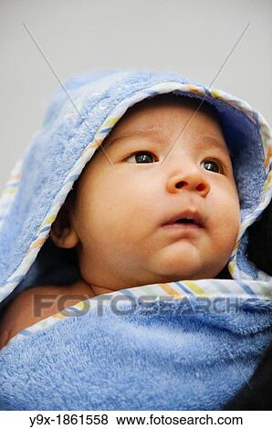 A mixed ethnicity baby wrapped in a blue towel blanket View Large Photo Image Stock Photo - A mixed ethnicity baby wrapped in a blue towel blanket. Fotosearch