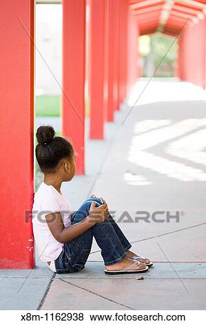 A mixed race little black girl quitely sits in a school yard View Large Photo Image Stock Photo - A mixed race little black girl quitely sits in a school yard. Fotosearch