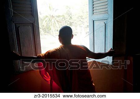 A monk opens a window in a small village temple outside of Phnom Penh, Cambodia. View Large Photo Image Picture - A monk opens a window in a small village temple outside of Phnom Penh, Cambodia.. Fotosearch