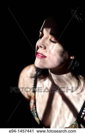 A moody, shadowy portrait of a nineteen year old brunette woman, grinning looking away from the camera View Large Photo Image Stock Image - A moody, shadowy portrait of a nineteen year old brunette woman, grinning looking away from the camera. Fotosearch