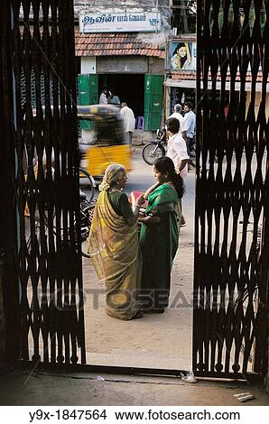 A mother and daughter dressed in traditional Hindu garb talking outside a metal gate on the streets of India View Large Photo Image Picture - A mother and daughter dressed in traditional Hindu garb talking outside a metal gate on the streets of India. Fotosearch