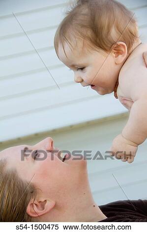 A mother and her eight-month-old baby outdoors. View Large Photo Image Stock Photography - A mother and her eight-month-old baby outdoors.. Fotosearch