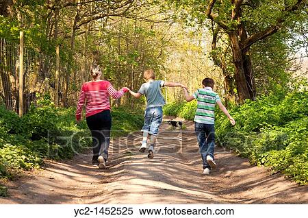 A mother and her two sons do 1, 2, 3, jump as they walk the dog down a country track in Spring in the Uk View Large Photo Image Stock Photography - A mother and her two sons do 1, 2, 3, jump as they walk the dog down a country track in Spring in the Uk. Fotosearch
