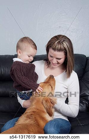 A mother holds her young son indoors. View Large Photo Image Stock Photo - A mother holds her young son indoors.. Fotosearch