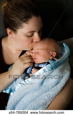 A mother kisses her two-week-old son, who is holding onto her finger View Large Photo Image Picture - A mother kisses her two-week-old son, who is holding onto her finger. Fotosearch