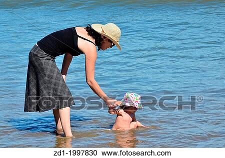 A mother play with here baby child at sea during summer vacation. View Large Photo Image Stock Image - A mother play with here baby child at sea during summer vacation.. Fotosearch