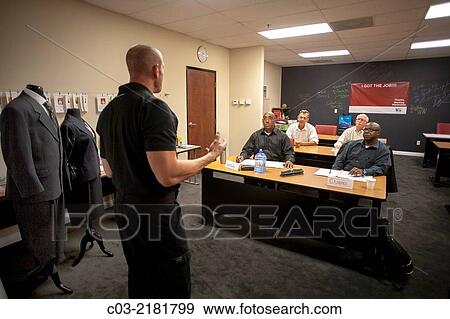 Stock Photo - A motivational speaker lectures at a "Men's Career Workshop" on new business attire from Working Wardrobes, a organization helping the unemployed dress and groom for successful business job interviews in Southern California. MODEL RELEASE.. Fotosearch