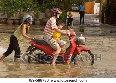 A motorcyclist driving through a flooded street in Sukhothai. Torrential rains over the past few weeks have resulted in major floodings in most of northern Thailand, with the Uttaradit and Sukhothai areas being most affected View Large Photo Image Stock Image - A motorcyclist driving through a flooded street in Sukhothai. Torrential rains over the past few weeks have resulted in major floodings in most of northern Thailand, with the Uttaradit and Sukhothai areas being most affected. Fotosearch