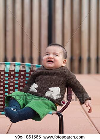 A multi ethnic baby boy with a funny knit sweat sits on a chair View Large Photo Image Stock Photography - A multi ethnic baby boy with a funny knit sweat sits on a chair. Fotosearch