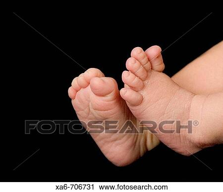 A newborn baby's feet against a black background. View Large Photo Image Stock Image - A newborn baby's feet against a black background.. Fotosearch
