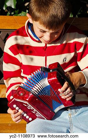 A nine year old boy playing an accordian in a Uk garden View Large Photo Image Stock Image - A nine year old boy playing an accordian in a Uk garden. Fotosearch