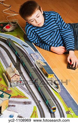 A nine year old boy playing with his electric trainset View Large Photo Image Stock Photo - A nine year old boy playing with his electric trainset. Fotosearch