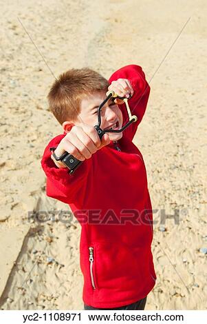 A nine year old boy with his catapult on a uk beach View Large Photo Image Stock Image - A nine year old boy with his catapult on a uk beach. Fotosearch