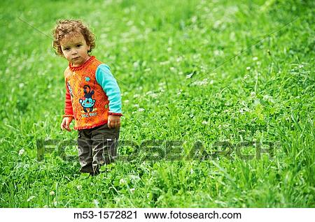 A one year old baby girl playing in a green meadow View Large Photo Image Stock Image - A one year old baby girl playing in a green meadow. Fotosearch