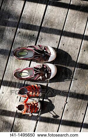 A pair of adult, and a pair of child? s, water shoes, laying out on a porch in the summer sun to dry View Large Photo Image Stock Image - A pair of adult, and a pair of child? s, water shoes, laying out on a porch in the summer sun to dry. Fotosearch