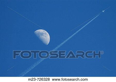 A passenger jet flies so high it appears to pass by the moon. View Large Photo Image Stock Photo - A passenger jet flies so high it appears to pass by the moon.. Fotosearch