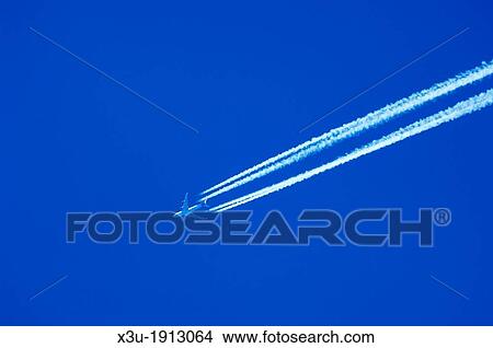 A passenger jet liner flying at high altitude leaving vapour trails against a clear blue sky View Large Photo Image Picture - A passenger jet liner flying at high altitude leaving vapour trails against a clear blue sky. Fotosearch