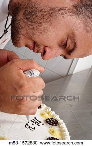 A pastry chef decorating a cake with chocolate cream View Large Photo Image Stock Image - A pastry chef decorating a cake with chocolate cream. Fotosearch