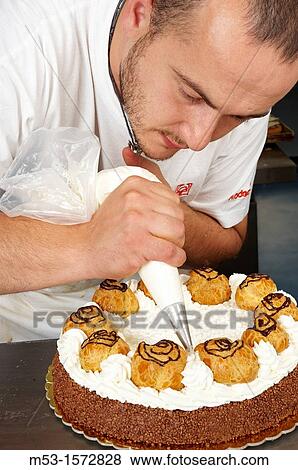 A pastry chef decorating a cake with whipped cream View Large Photo Image Stock Photo - A pastry chef decorating a cake with whipped cream. Fotosearch