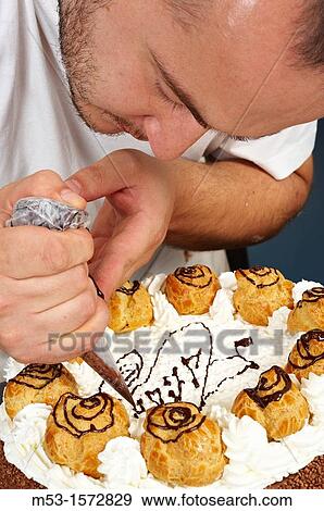 A pastry chef decorating a cake with whipped cream View Large Photo Image Stock Photo - A pastry chef decorating a cake with whipped cream. Fotosearch
