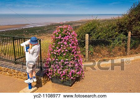 A pay to view telescope looking out to sea being used by a young child at Hunstanton, North Norfolk, Uk View Large Photo Image Stock Photo - A pay to view telescope looking out to sea being used by a young child at Hunstanton, North Norfolk, Uk. Fotosearch