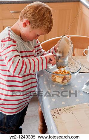 Stock Photography - A photo of a seven year old boy preparing cooking ingredients in the Uk. Fotosearch