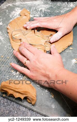 Stock Photo - A photo of a woman cutting out gingerbread men in the Uk. Fotosearch